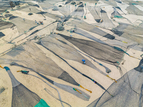 Aerial view of fishing nets spread across the sandy expanse, creating a textured tapestry under the sun, Cox's Bazar, Chittagong Division, Bangladesh.