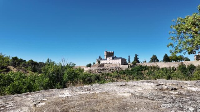 The Alc&aacute;zar of Segovia is one of the most iconic castles in Segovia, rising dramatically above the rocky cliffs where two rivers meet. From a distance as I walk on the outskirts