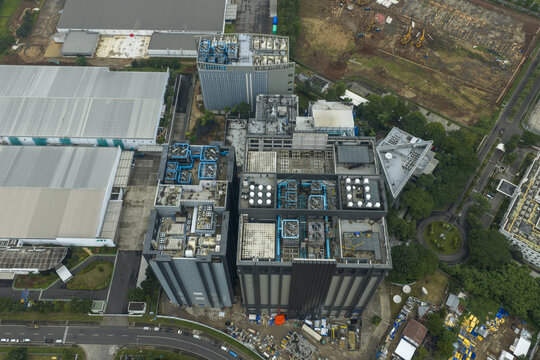 Aerial view of large ai datacenter building complex with cooling units and industrial facilities, Jakarta, Indonesia.