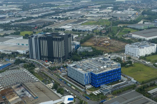 Aerial view of large blue data center building, other industrial facilities, and new construction, Jakarta, Indonesia.