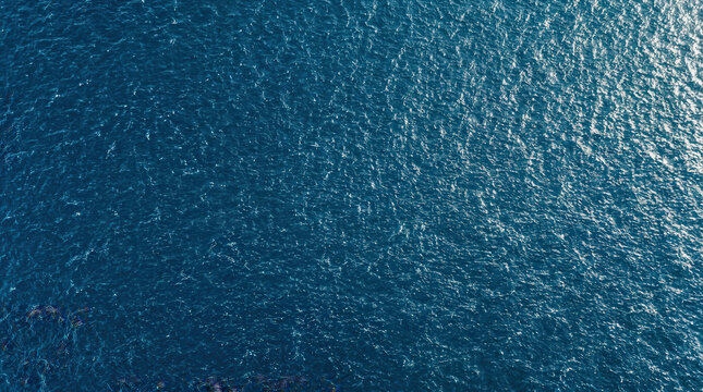 Aerial View of Sparkling Ocean Surface with Sunlight Reflection on Wave Patterns