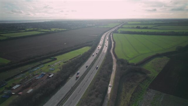Aerial Drone View of Traffic on A12 Motorway Passing Through Rural Farmland