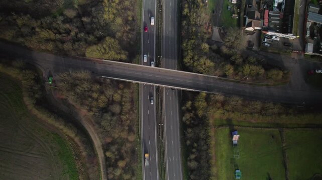 Top Down Aerial View of Bridge Crossing A12 Motorway with Moving Traffic in Essex, England