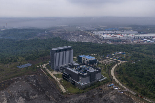 Aerial view of a large ai data center complex and surrounding industrial development amidst green areas under an overcast sky, Kuala Lumpur, Malaysia.