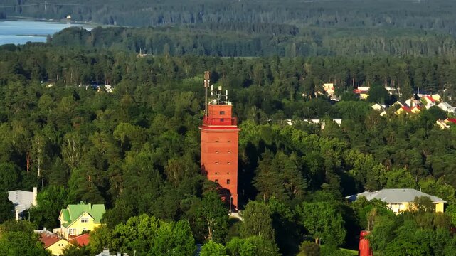 Telephoto drone shot around the watertower of Ekenas, summer sunset in Finland
