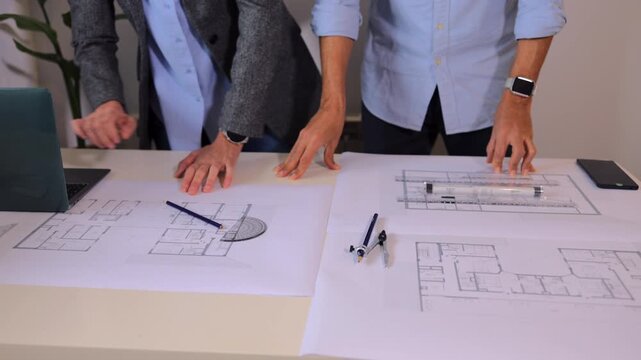 Professional architects discussing blueprints in an office. A creative team of engineers reviewing construction plans, brainstorming ideas for a new architectural project
