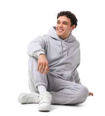Obraz premium Young man in grey sports suit sitting on white background