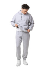 Fototapeta premium Young man in grey sports suit on white background