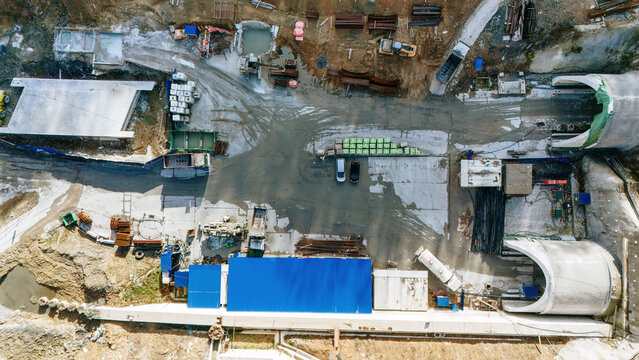 Aerial view of construction site with tunnel entrances and heavy machinery, a scene of industry against the earth, Novi Sad, Vojvodina, Serbia.