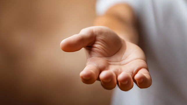 Faceless man's strong hand extended outward in an offering gesture, palm open, defocused neutral warm background, helping hand concept, support gesture, care and kindness, charitable reach,