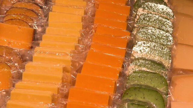 Assorted varieties of prepackaged cheese blocks displayed for sale at market