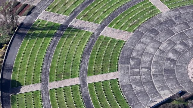 Aerial view of the solemn cemetery with rows of white grave markers contrasting against the green grass, Mittelwihr, Grand Est, France.