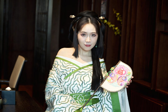 Asian beauties dressed in Hanfu (Warring States period robes) and Weixian paper-cutting