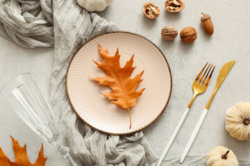 Naklejka premium Beautiful table setting with autumn leaves, walnuts and pumpkins on white background