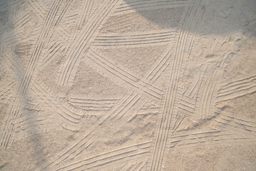 Traces of car tires on the sand in the park, closeup of photo
