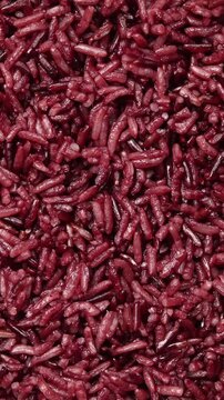 Pile of cooked riceberry rice rotating slowly. Top view shot