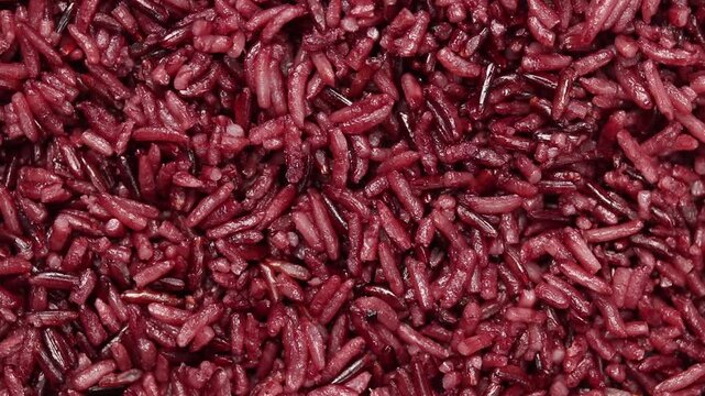 Pile of cooked riceberry rice rotating slowly. Top view shot