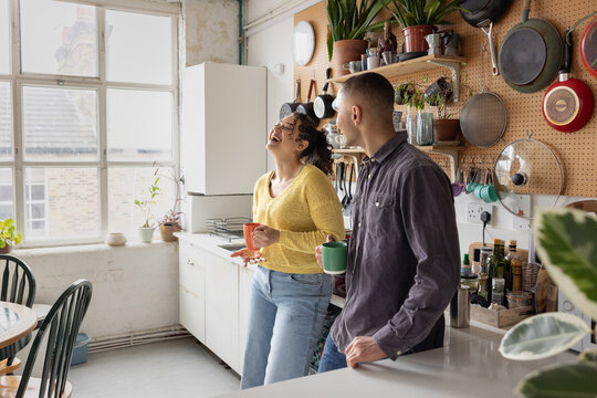 Roomies socialising over coffee in their kitchen