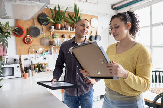 Couple deciding where to hang pictures in their new home