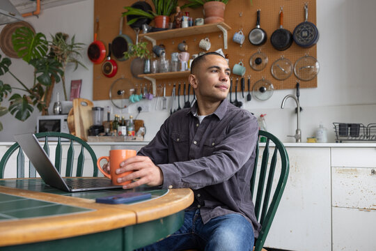 Young man taking a break whilst working from home in the kitchen