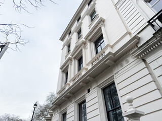Naklejka premium Elegant white building with neoclassical columns and ornate windows in London UK facade details shown