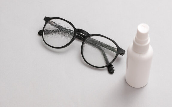 Spray bottle for cleaning lens and eyeglasses on gray background