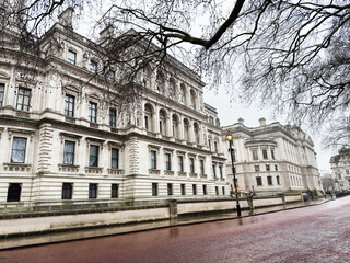 Naklejka premium Historic London streetscape with grand neoclassical building and lampposts on a rainy day