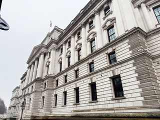 Naklejka premium Imposing classical London HM Treasury building with stone columns and ornate facade along a grand street