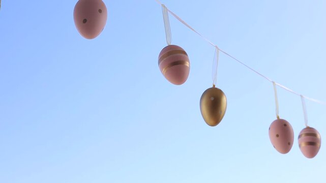 Hanging Decorated Eggs Against Blue Sky