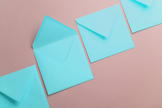 Blue square paper envelopes on pink pastel background
