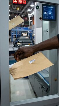 Mail sorting machine in action, processing envelopes with precision and speed.