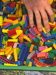 Naklejka premium Hand reaching into colorful building bricks