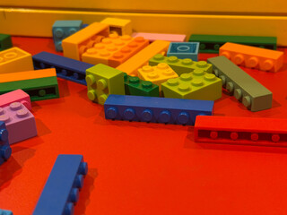 Naklejka premium Colorful toy building blocks on red surface