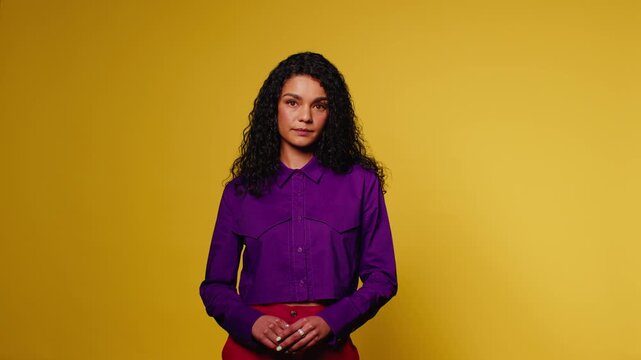 Confident woman poses against a vibrant yellow background
