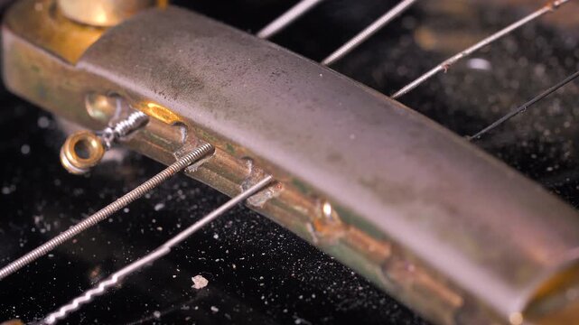 Close up of replacing electric guitar strings, restringing process, instrument maintenance, musician setup and repair concept.