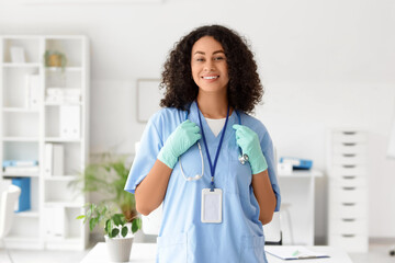 Female African-American medical student with stethoscope and gloves in office