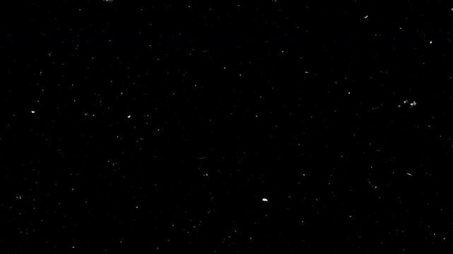 Animation cinematic film dust and heavy grain texture overlay on black background. Vintage style grunge motion effect features realistic white particles, scratches and fibers, perfect for adding an an