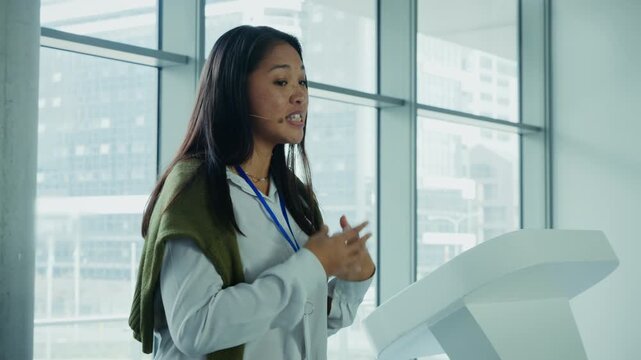 Professional woman speaking at a podium during a conference with city views