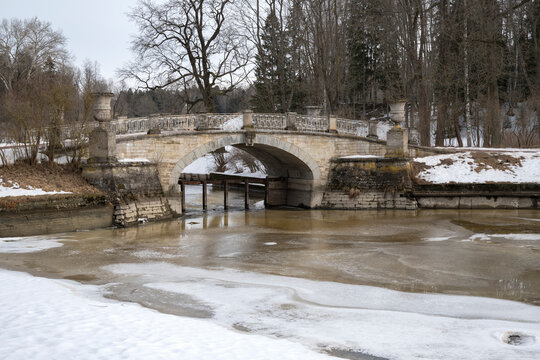 The ancient Viscontiev Bridge over the Slavyanka River on a March morning. Pavlovsk Park (Saint Petersburg)