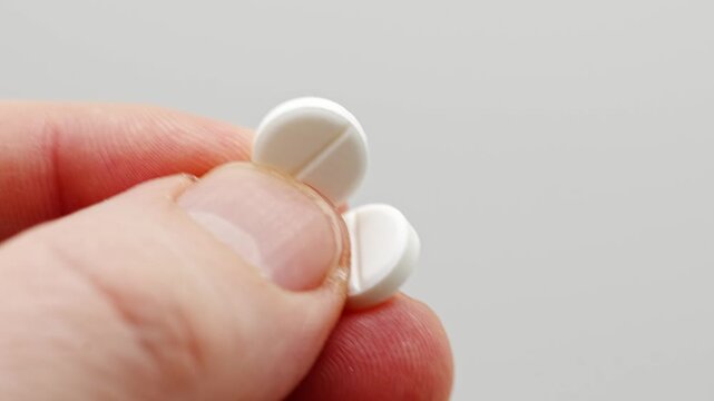 Holding and breaking a tablet into two pieces with hands