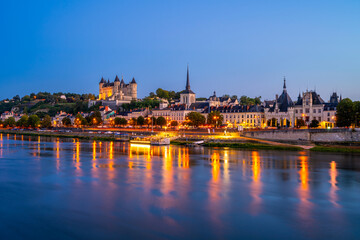 Fototapeta premium Long exposure of Saumur, Pays de la Loire, Northwestern France on summer evening at dusk. The Loire River flows through Saumur.