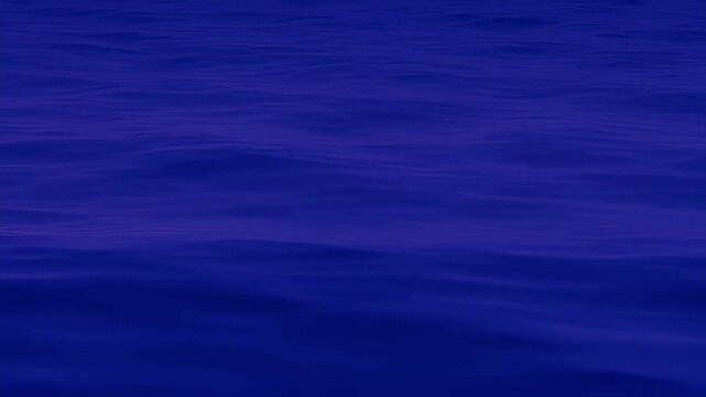 Serene and monochromatic blue ocean waves gently rippling under dim lighting conditions