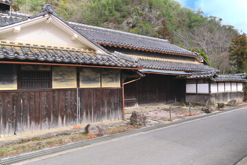 日本の原風景：田舎の静かな道と古い橋、伝統的な家屋が並ぶノスタルジックな風景 © taka