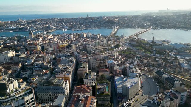 Aerial view of the Galata Tower, Ataturk and Halic bridges spanning across the waters, with buildings clustered tightly together, Istanbul, Turkey.