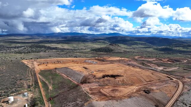 Aerial view of the expansive Gray Wolf Regional Landfill, a landscape of contrasting earth tones against the backdrop of distant mountains, Dewey, Arizona, United States.