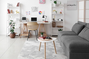 Fototapeta premium Interior of living room with workplace, sofa and shelf units
