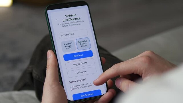 Using Vehicle History App to Check Car VIN Records. Close-up of a person using a mobile app to verify car history. User pays for a report and reviews VIN details, mileage, and accident records. 