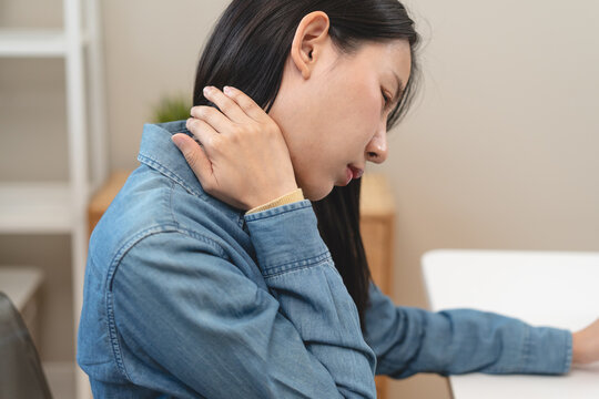 female office worker rubbing her neck feel pain at her back and shoulder.