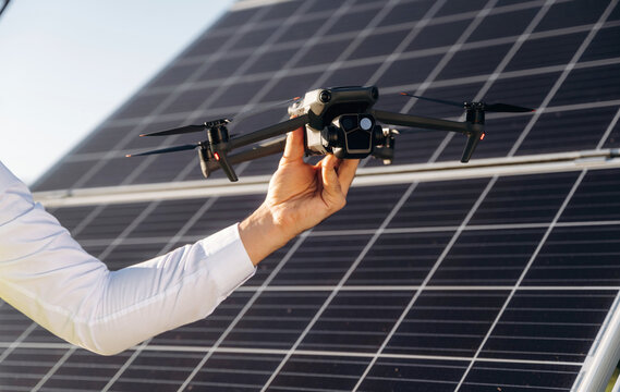 Modern drone conception, control. Male solar engineer examining photovoltaic panels at a power station