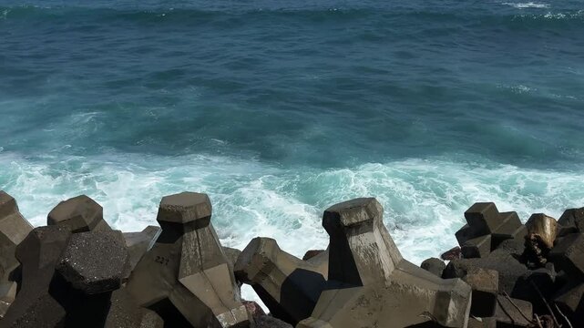  High-speed 4K footage of powerful ocean waves crashing against concrete tetrapods